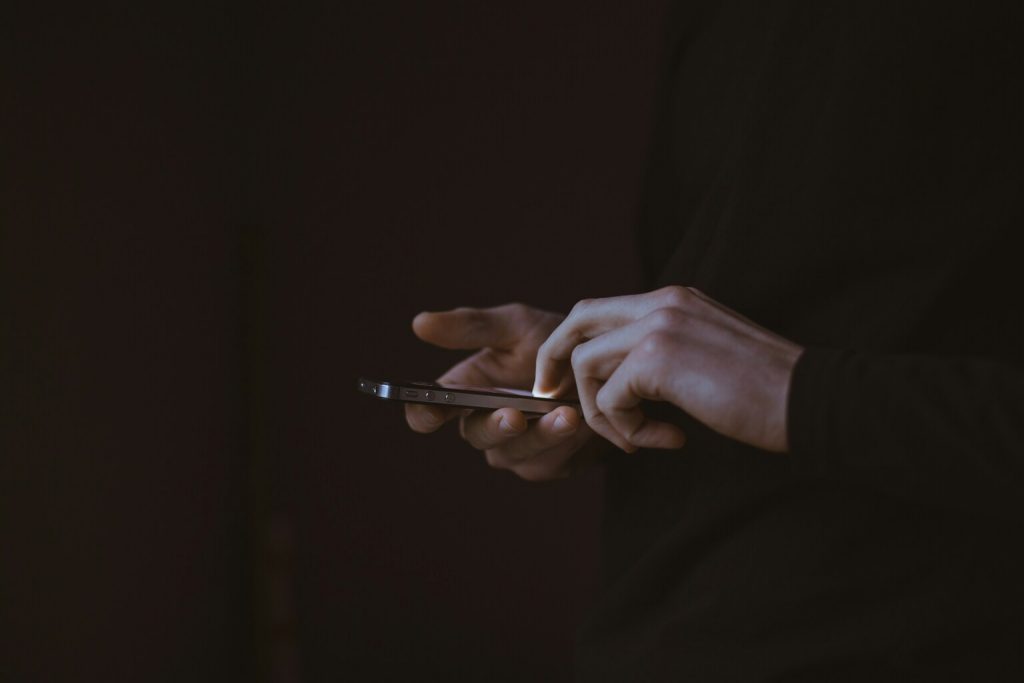 A silhouette photo of-person holding smartphon.