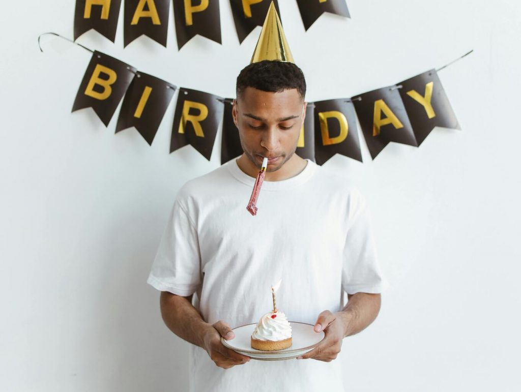 a birthday guy holding a cake