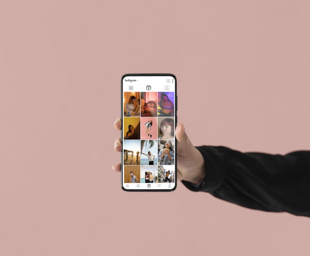 hand holding smartphone with multiple videos on Instagram