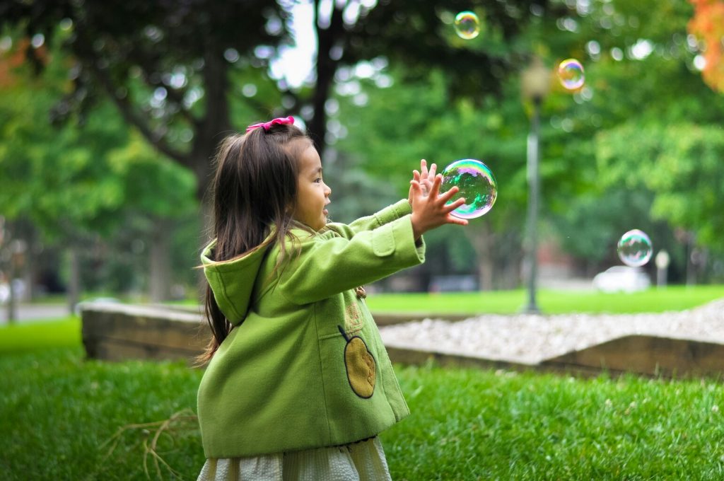 photo of a girl holding bubbles