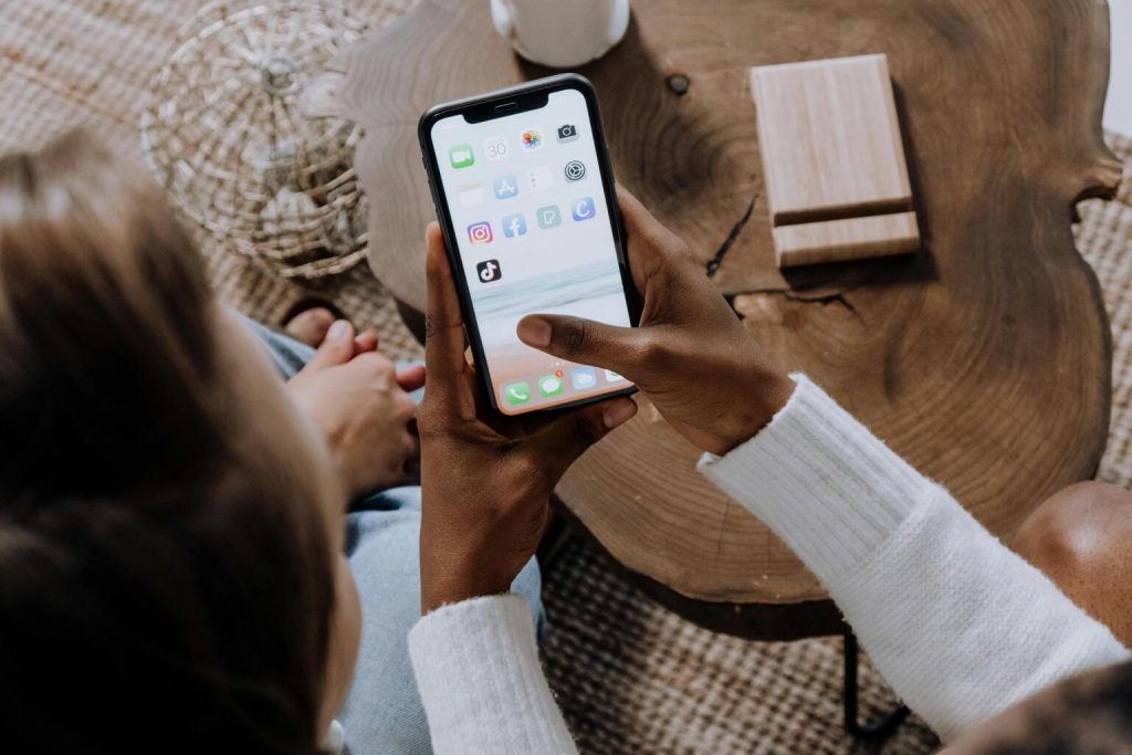 hands holding a smartphone with TikTok logo on screen