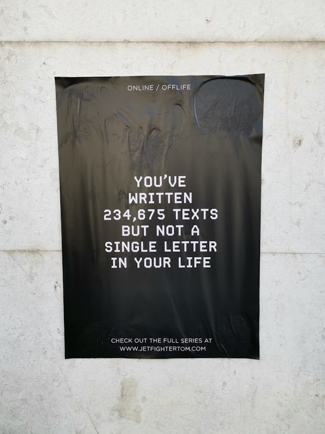 An advertisement with a black background and white text on a wall.