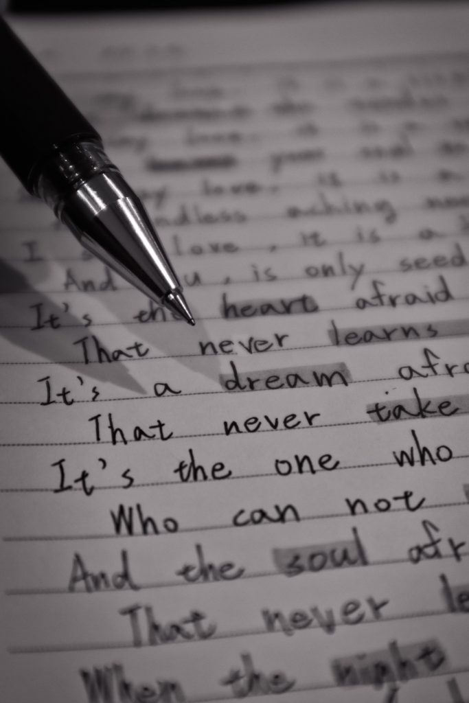 A close-up of a pen above a sheet of paper.